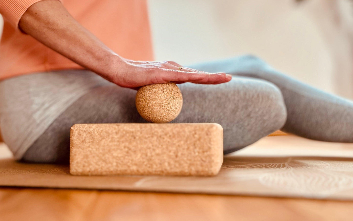Faszien-Training für die Handinnenfläche mit mittleren Faszienball aus Kork auf Yogablock zur Unterstützung
