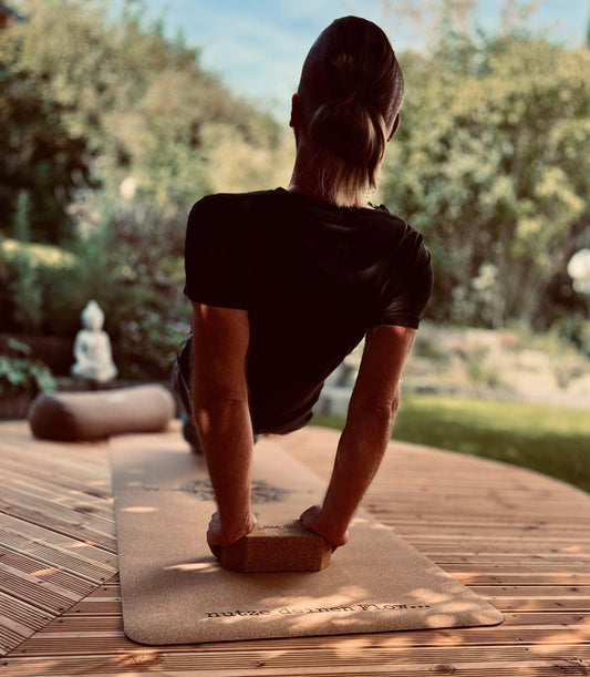 Stefan Gründer und CEO mit einem Reserve Plank auf der Yogamatte Kork Kompass mit Unterstützung von einem Yogablock